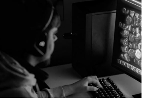 En person som sitter och spelar på en dator